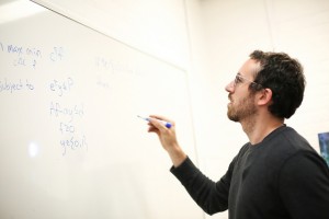 Justin Boutilier writing a formula on a whiteboard